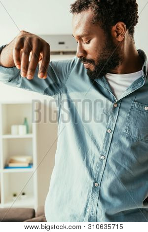 Young African American Man In Sweaty Shirt Suffering From Aummer Heat At Home