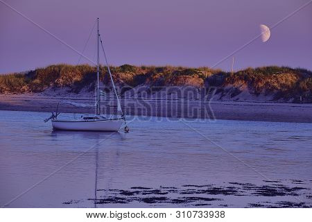 Small Sailing Boat Lying At Benodet Beach In Brittany With Half Moon Over The Dune