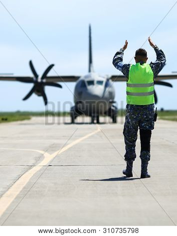 Boboc, Romania - May 22, 2019: Ground Personnel Is Aircraft Marshalling An Alenia C-27j Spartan Mili