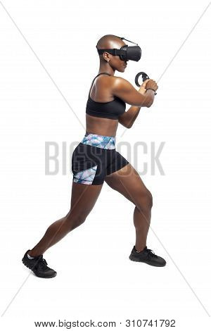 Athletic Woman Exercising While Playing Video Game By Practicing Vr Sword Fighting Or Swordplay With