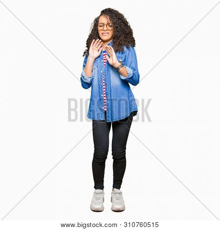 Young beautiful woman with curly hair wearing glasses disgusted expression, displeased and fearful doing disgust face because aversion reaction. With hands raised. Annoying concept.