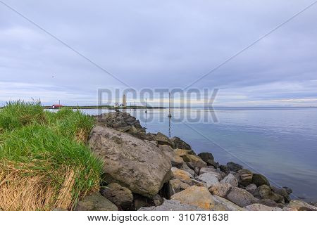 Island Grotta Near Reykjavik In The Morning With Clouds In The Sky. Lighthouse And Houses In The Bac