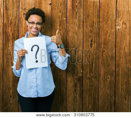 Young african american woman holding paper with question mark over isolated background happy with big smile doing ok sign, thumb up with fingers, excellent sign