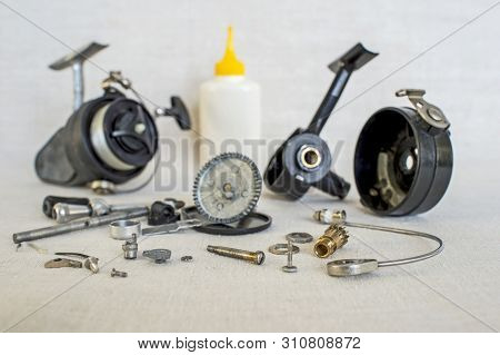 A Fishing Spinning Reel As A Whole And A Second Similar Completely Disassembled. Concept: Parts Of A
