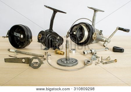 A Fishing Spinning Reel As A Whole And A Second Similar Completely Disassembled. Concept: Parts Of A