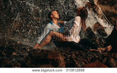 A Couple In Love During Lovemaking Under The Streams Of A Waterfall.