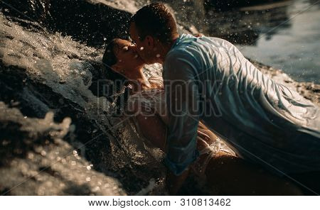 A Couple In Love During Lovemaking Under The Streams Of A Waterfall.