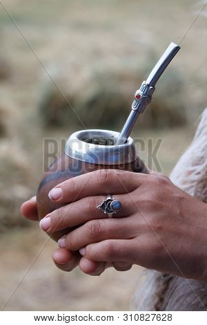 Womans Hands Holds Traditional Calabash Gourds For Yerba Mate On The Wooden Surface, Selective Focus