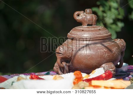 Close-up Chinese Red Clay Teapot With Traditional Stucco On A Table With Fruit, Selective Focus