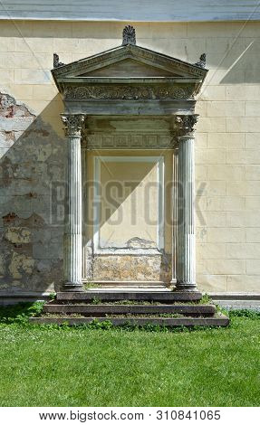 Portico With Columns At The Old House And Green Summer Lawn