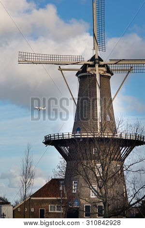 Windmill In Leiden, Netherlands With The Airplane In The Background