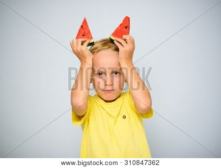 Frolicsome Caucasian 5 Year Old Boy Child In Yellow T-shirt Holding Two Pieces Of Red Watermelon Abo