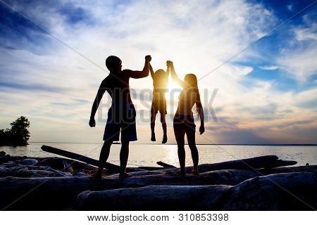 Happy Family Silhouette On The Sunset Background