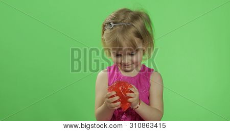Child Having Fun Making Red Slime. Kid Playing With Hand Made Toy Slime. Funny Kid Girl. Relax And S