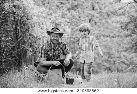 Planting Flowers. Growing Plants. Take Care Of Plants. Boy And Father In Nature With Watering Can. G