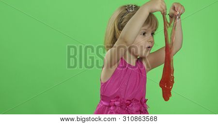 Child Having Fun Making Red Slime. Kid Playing With Hand Made Toy Slime. Funny Kid Girl. Relax And S