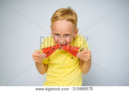 Frolicsome Caucasian 5 Year Old Boy Without Incisor Capering And Eating Pieces Of Red Watermelon, De
