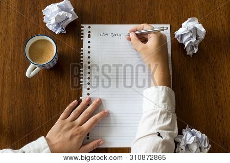 I Am Sorry Written On Paper With Coffee On Wooden Table Hands Of A Person