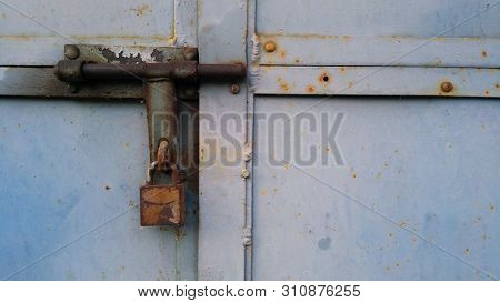 Rusty Old Lock Hanging On Rusty Weathered Iron Door Locked Up