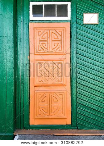 Old Wooden Door In A Rustic House Decorated With Carved Traditional Sacred Buddhist Symbols In Tuva 