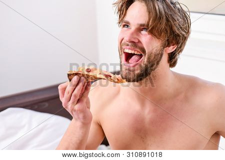 Cropped Image Of Shirtless Sexy Man With Pizza On Bed. Man Bearded Handsome Guy Eating Cheesy Food F