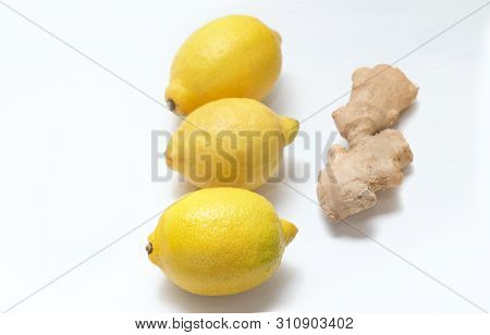 Three Yellow Lemons And Ginger Root On A Light Background.
