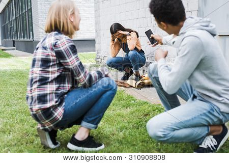 African American Boy And Blonde Teenager Shooting Scared Brunette Teenager