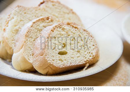 Poudered Slices Of Bread In A White Plate On The Wooden Table