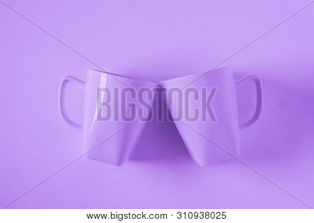 Purple Coffee Mugs On Purple Background Clinking In Cheers With Empty Copy Space
