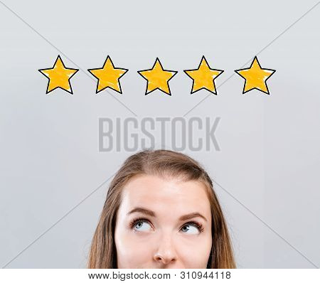 Five Star Rating With Young Woman Looking Upwards