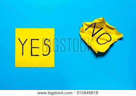 Close Up Black Handwritten Inscription Yes And No Word On Two Yellow Square Stickers On Blue Backgro