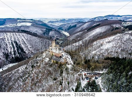 Aerial View Rock With Medieval Castle On It Near Moselle River In Brodenbach Winter With Forest Snow