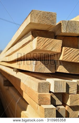 Stacked Lumber On Blue Sky.folded Wood.closeup Wooden Boards.the Surface Of The End Of The Board.lot
