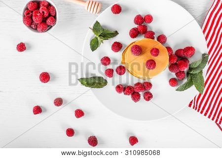 Top View Of Pancakes With Raspberries On White Wood Background