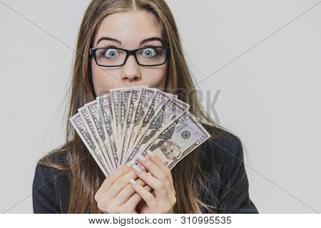 Happy Excited Young Business Woman Is Showing A Pile Of Money, Isolated On White Background. Girl Is