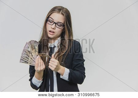 Concentrated Young Business Woman Is Counting A Pile Of Money, Isolated On White Background. Girl Is