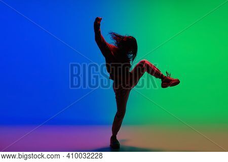 Modern. Stylish Sportive Girl Dancing Hip-hop In Stylish Clothes On Colorful Background At Dance Hal