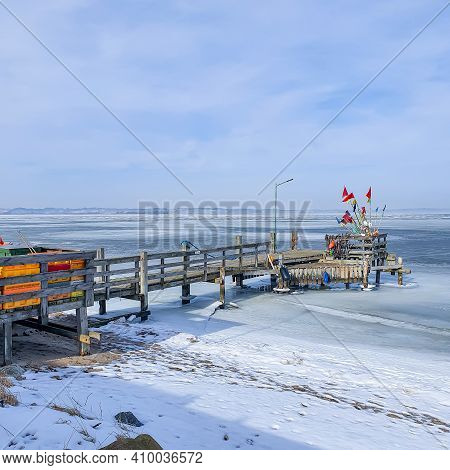 A Short Wooden Pier On The Shore Of The Frozen Sea