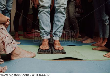 Group practice of standing on nails. Closeup of yoga person standing on sadhu board with sharp nails