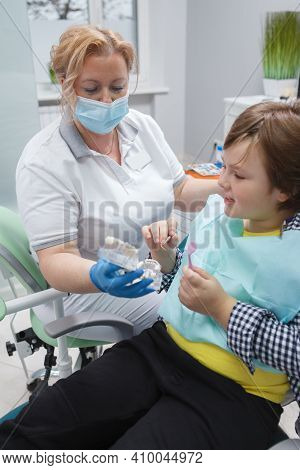 Vertical Shot Of A Professional Dentist Talking To Her Young Patient After Dental Examination