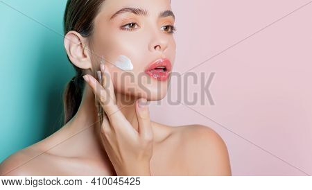Closeup Portrait Of Girl With Healthy Clean Skin. Attractive Young Woman Putting Anti-aging Cream On