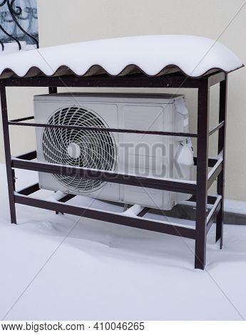 The Outdoor Unit Of The Air Conditioner (air-to-air Heat Pump) In The Snow During Winter Operation.