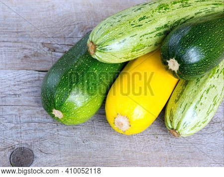 Zucchini On Wooden Background. Yellow And Green Zucchini. Vegetable Marrow Courgette Or Zucchini. Ha