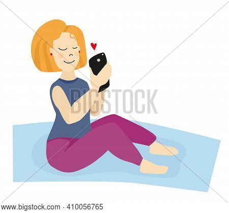 A Girl With Blonde Hair On A Yoga Mat Looks At Her Phone And Receives A Love Message