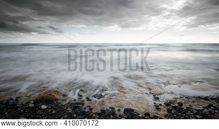 Seawaves Splashing To The Coast With Pebbles Against Stormy Dramatic Cloudy Sky. Wintertime, Longexp