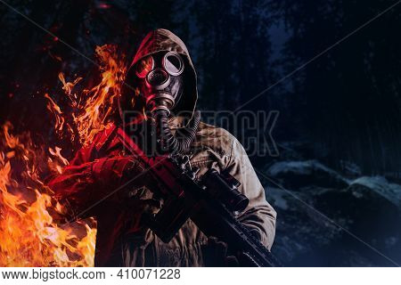 Photo Of A Post Apocalyptic Stalker Soldier In Gas Mask And Hood Jacket Holding Rifle And Standing O