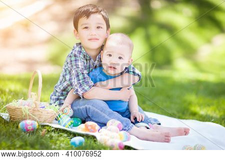 Mixed Race Chinese and Caucasian Boys Outside in Park Playing with Easter Eggs.