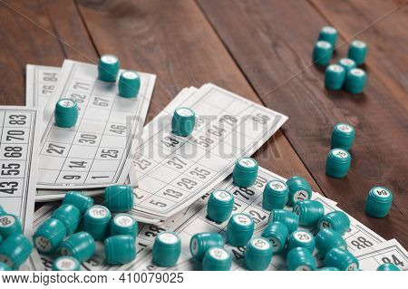 Many Barrels With Numbers And Cards For Lotto Or Russian Bingo Table Game On Wooden Surface. Russian
