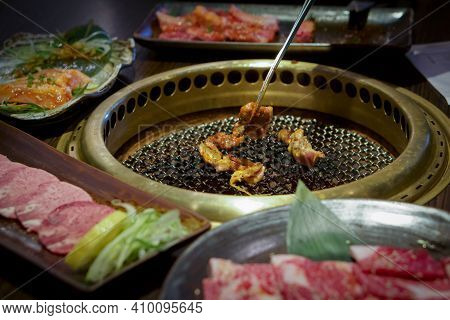 Japanese Barbecue On A Hot Chacoal Stove. Chicken Grilling On Griddle Pan.