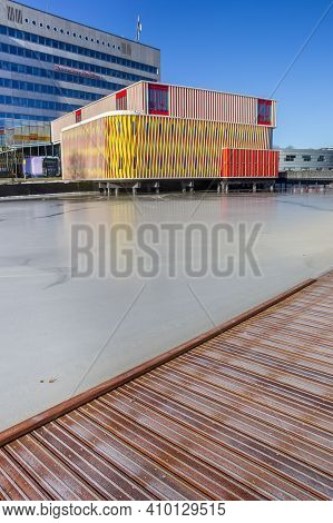 Groningen, Netherlands - February 13, 2021: Wooden Jetty In Front Of The Colorful Duisenberg Buildin